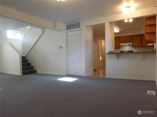 unfurnished living room with dark carpet