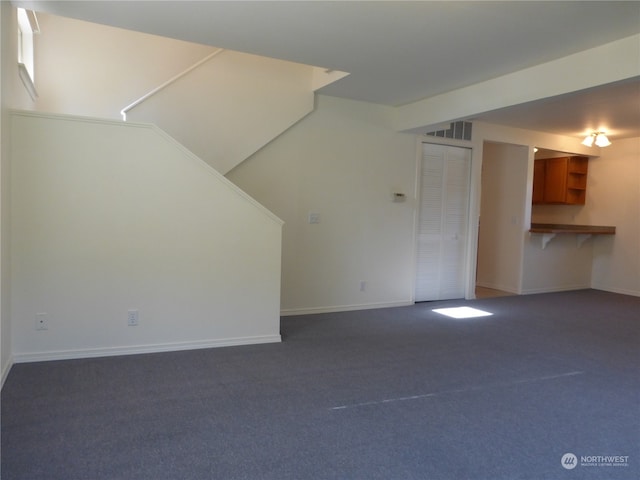 unfurnished living room featuring dark colored carpet