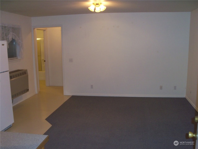 carpeted empty room featuring heating unit