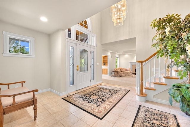 tiled foyer featuring a notable chandelier and a towering ceiling