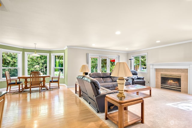 living room featuring ornamental molding, light hardwood / wood-style floors, a fireplace, and french doors