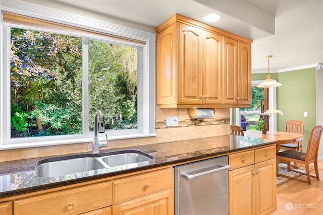 kitchen with light wood-type flooring, sink, decorative light fixtures, dark stone counters, and crown molding