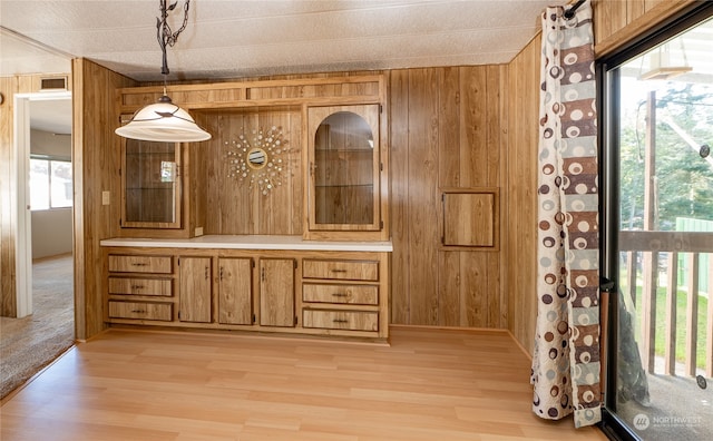 interior space with a textured ceiling, wood walls, and hardwood / wood-style floors