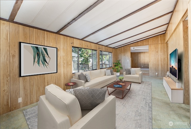 carpeted living room with lofted ceiling with beams and wood walls