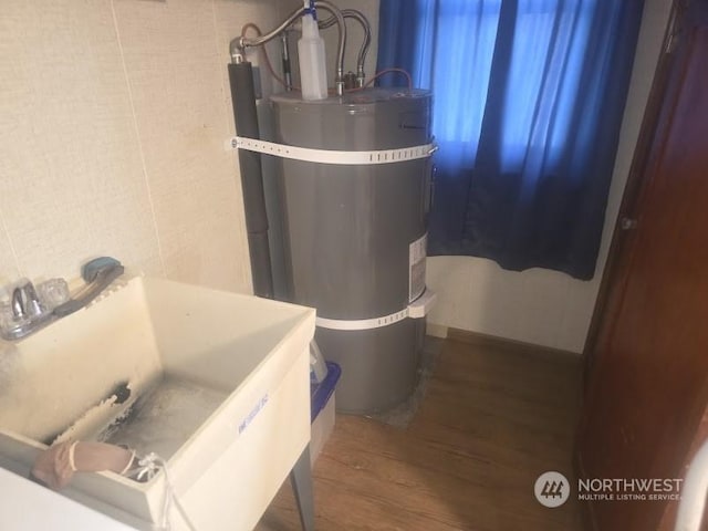 bathroom featuring a sink, secured water heater, and wood finished floors