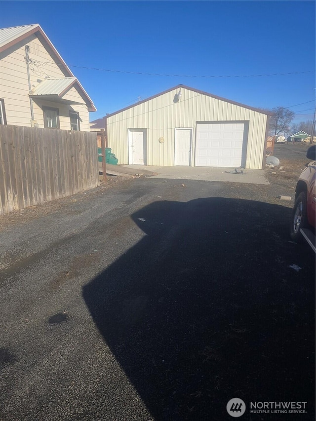 detached garage featuring fence