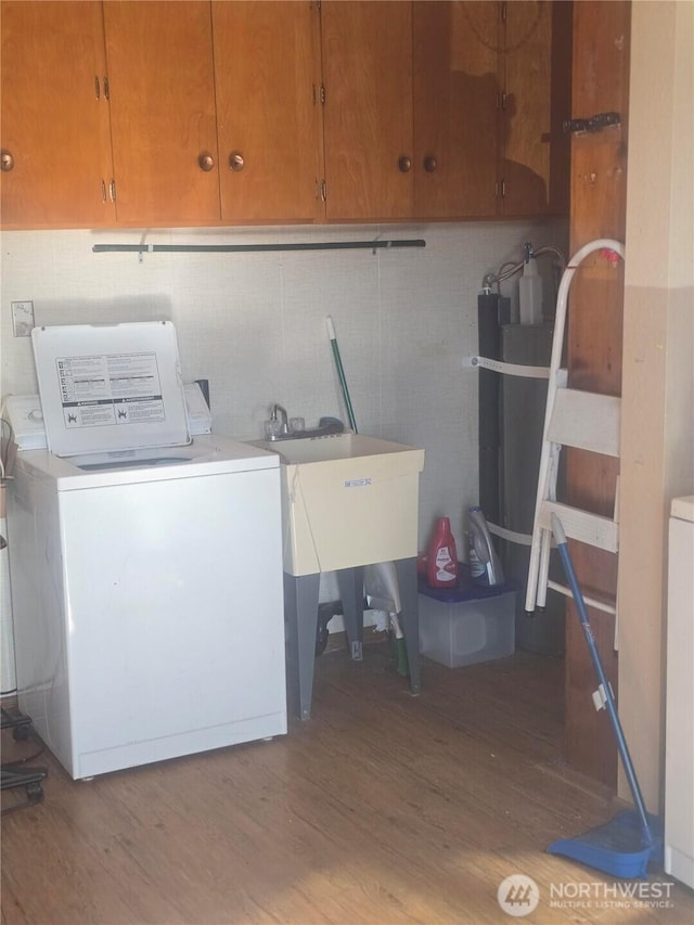 clothes washing area featuring cabinet space, washer / clothes dryer, and wood finished floors