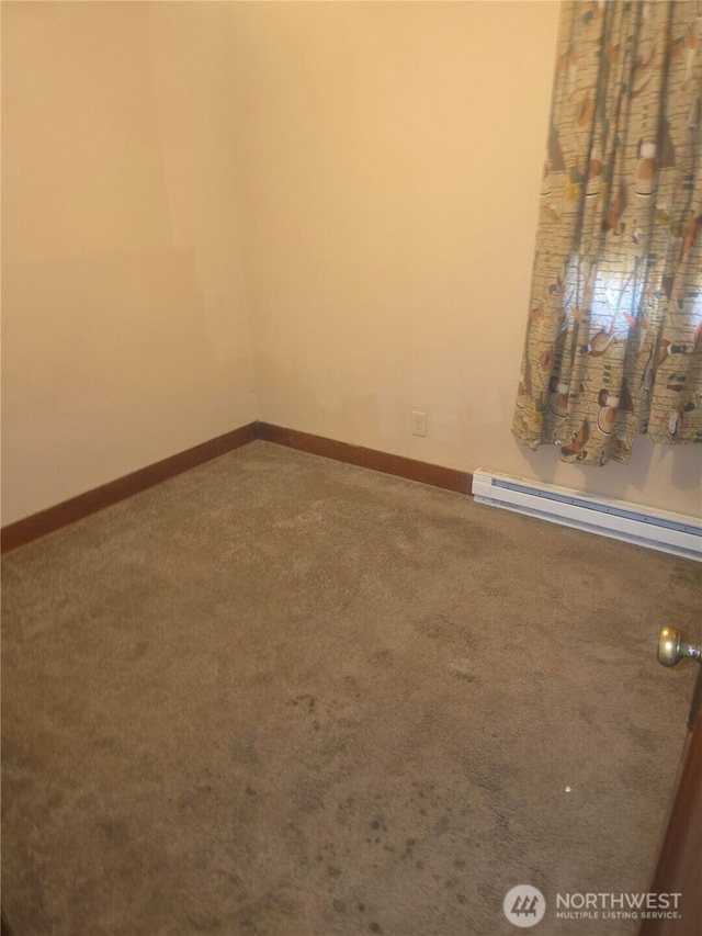 empty room featuring baseboards, carpet flooring, and baseboard heating