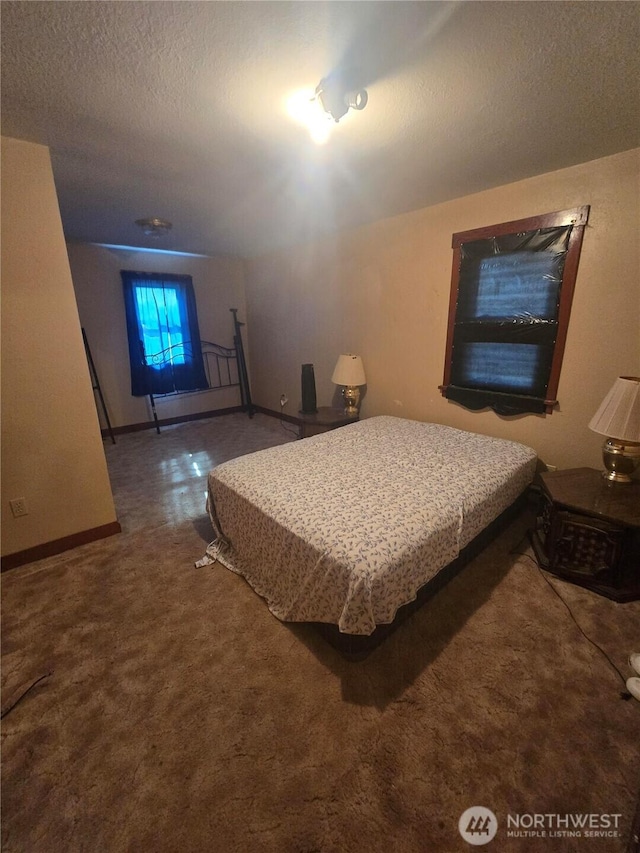 carpeted bedroom with a textured ceiling and baseboards