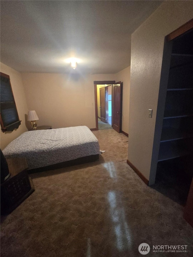 bedroom with concrete flooring and baseboards