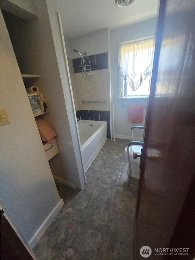 full bathroom with toilet, baseboards, and tub / shower combination