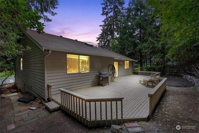 back house at dusk with a deck