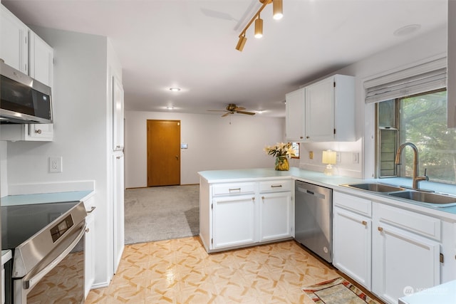 kitchen with ceiling fan, white cabinets, sink, kitchen peninsula, and stainless steel appliances