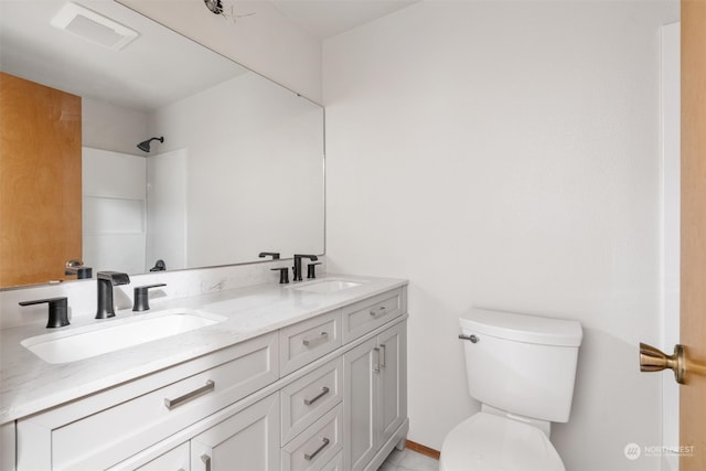 bathroom featuring a shower, vanity, and toilet