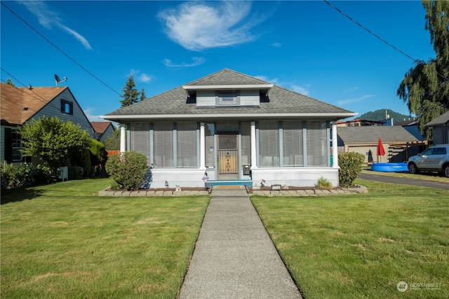 bungalow-style house with a sunroom and a front yard