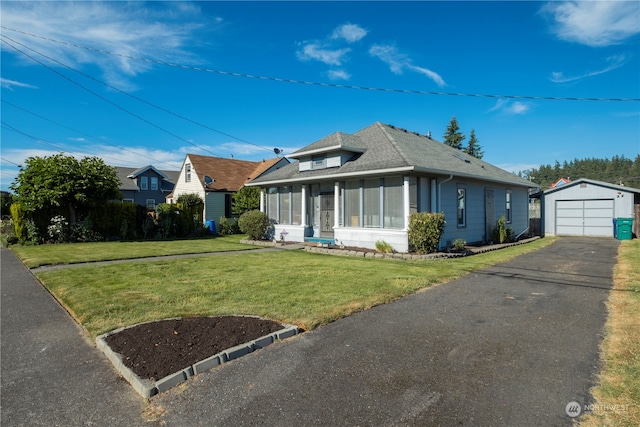 bungalow featuring a front yard, an outbuilding, and a garage