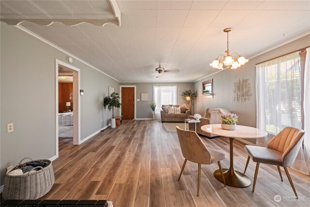 dining room with ornamental molding, a chandelier, hardwood / wood-style floors, and a healthy amount of sunlight