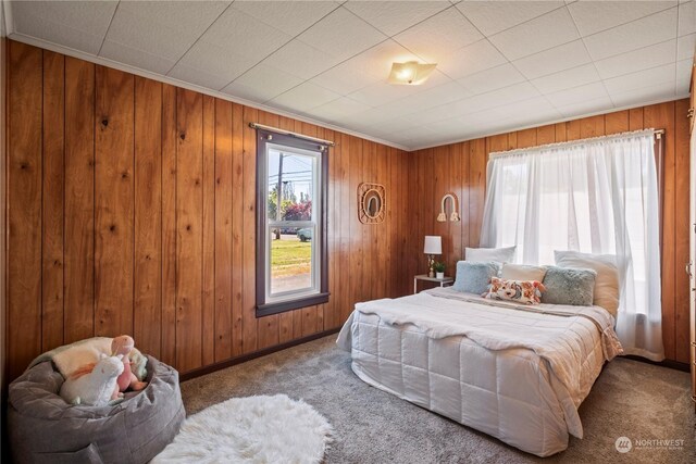 bedroom with carpet floors and wood walls