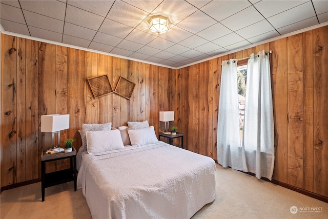 carpeted bedroom featuring wood walls