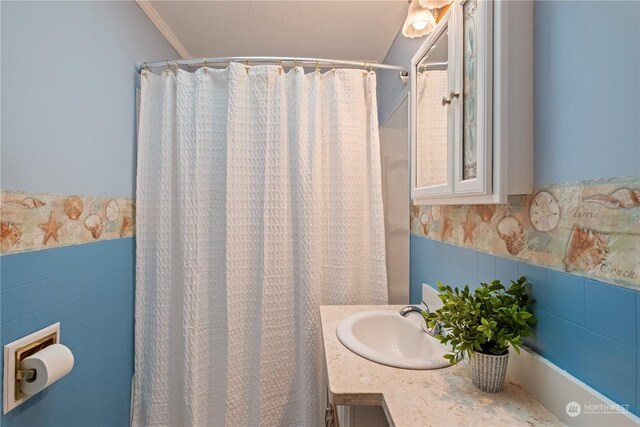 bathroom with vanity, tile walls, and crown molding