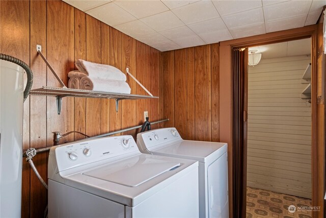 laundry area with washer and clothes dryer and wooden walls