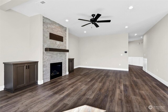 unfurnished living room featuring ceiling fan, a fireplace, and dark hardwood / wood-style floors