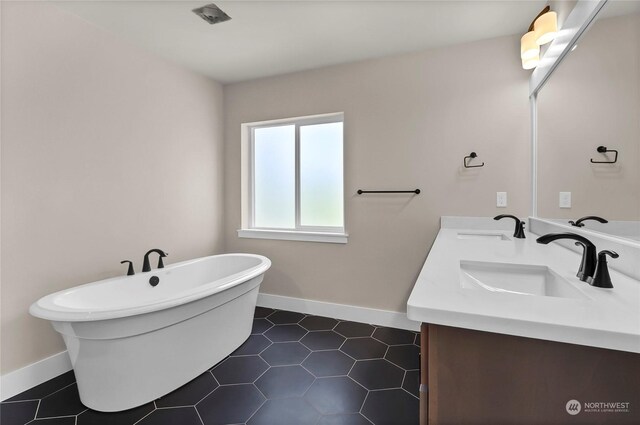 bathroom with tile patterned flooring, a washtub, and vanity