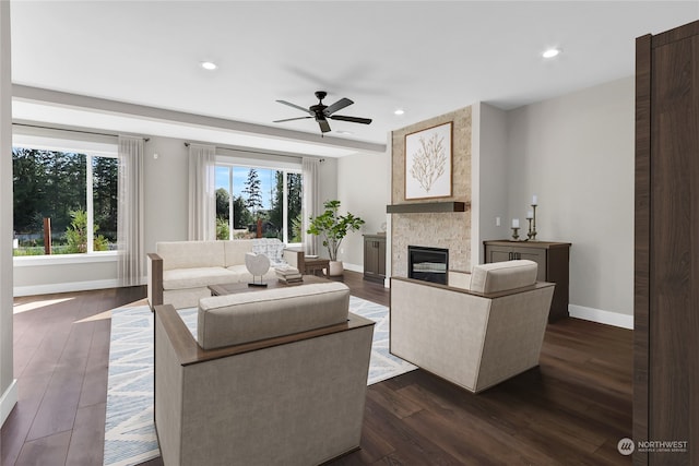 living room with ceiling fan, a fireplace, and dark wood-type flooring