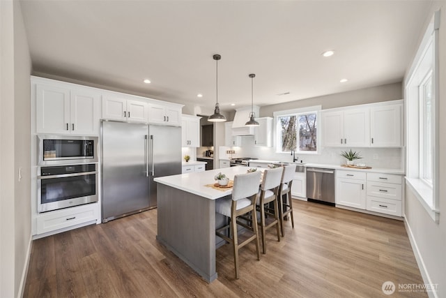7510 172nd Street Ct E, Puyallup, WA 98375 - kitchen with built in appliances, a kitchen island, recessed lighting, white cabinetry, and light countertops