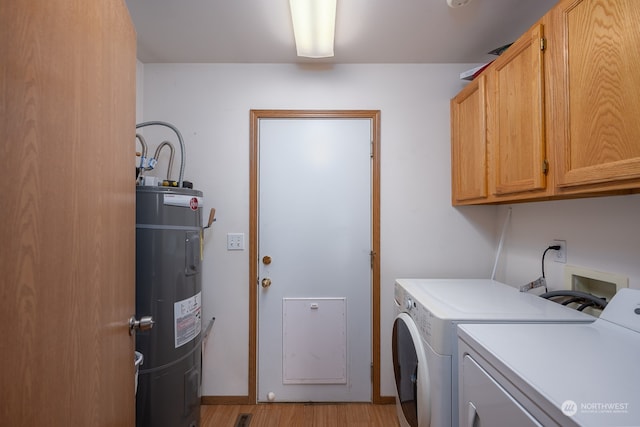 washroom with electric water heater, cabinets, light wood-type flooring, and independent washer and dryer