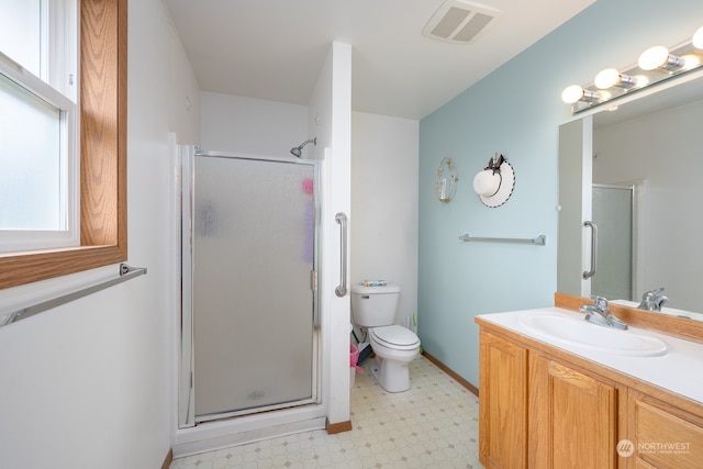 bathroom featuring a shower with door, vanity, and toilet