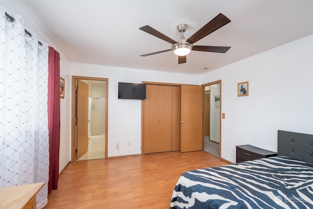 bedroom featuring a closet, ensuite bath, light wood-type flooring, and ceiling fan