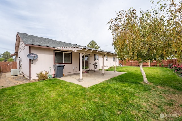 rear view of house featuring a lawn, a patio, and central AC