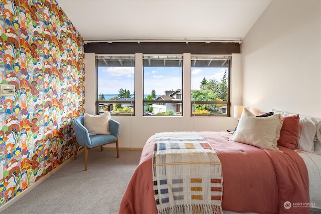 carpeted bedroom featuring lofted ceiling and multiple windows