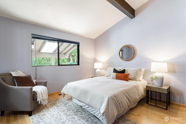 bedroom with vaulted ceiling with skylight and light hardwood / wood-style flooring