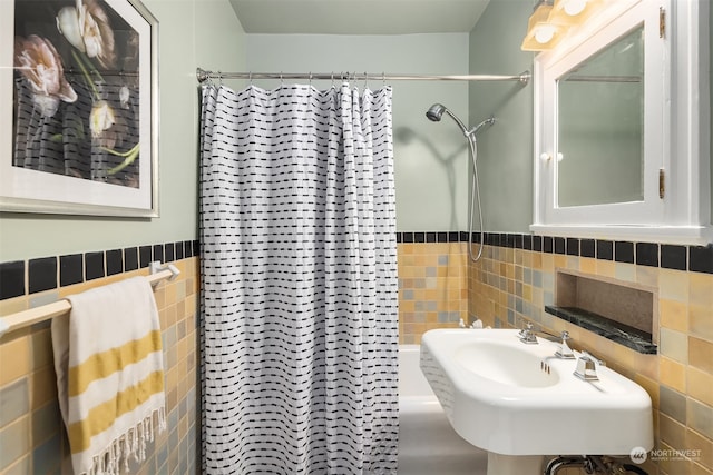 bathroom featuring tile walls, sink, and a shower with shower curtain