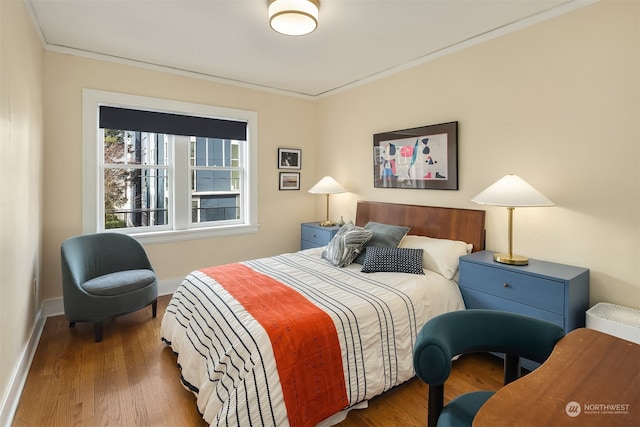 bedroom featuring ornamental molding and dark hardwood / wood-style flooring