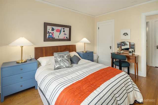 bedroom with hardwood / wood-style flooring and crown molding