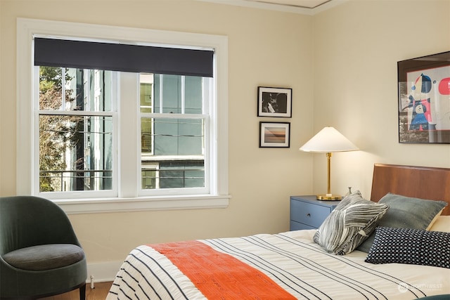 bedroom featuring ornamental molding and hardwood / wood-style floors