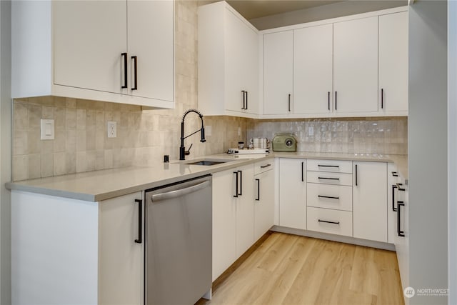 kitchen featuring light hardwood / wood-style floors, dishwasher, sink, and white cabinets