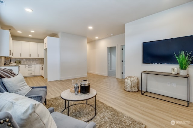 living room with sink and light hardwood / wood-style flooring