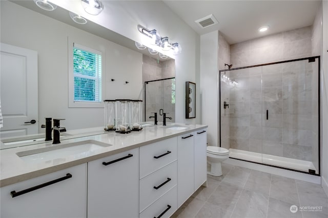 bathroom with tile patterned floors, an enclosed shower, vanity, and toilet