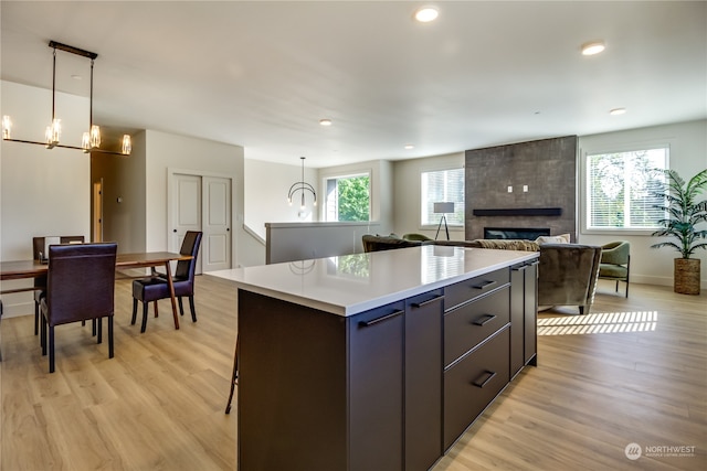 kitchen with a kitchen island, a wealth of natural light, hanging light fixtures, and a large fireplace