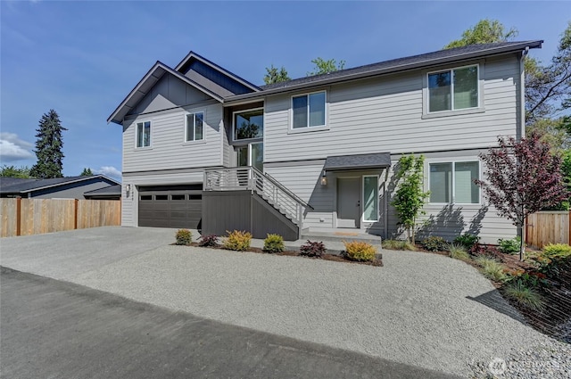 view of front of house featuring fence, driveway, and a garage
