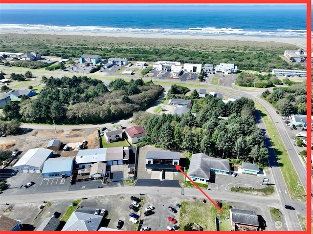 birds eye view of property featuring a water view and a beach view