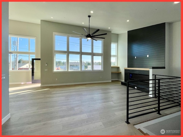 living room with light hardwood / wood-style flooring, ceiling fan, and plenty of natural light