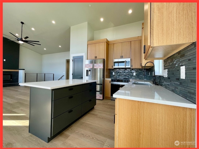 kitchen with light hardwood / wood-style flooring, backsplash, sink, a center island, and appliances with stainless steel finishes