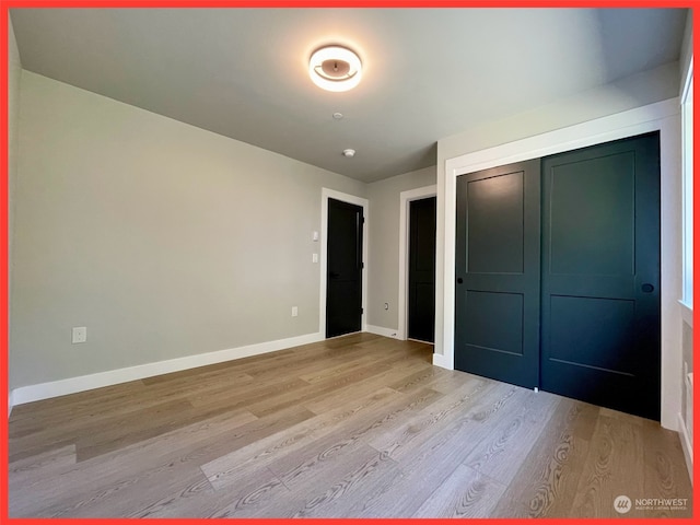 unfurnished bedroom with light hardwood / wood-style flooring and a closet