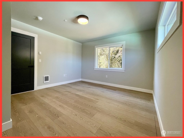 empty room with light hardwood / wood-style flooring