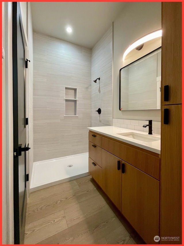 bathroom featuring vanity and tiled shower